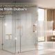 A luxurious modern bathroom featuring a sparkling clean custom shower glass partition with gold hardware, illustrating expert cleaning tips from Dubai glass specialists Majlis Hikma.